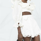 White embroidered shorts with scalloped hem and belted waist detail on model — Zimmermann | Endless UAE