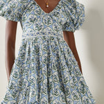 Woman wearing blue floral cotton mini dress with puff sleeves and cream tote bag — Agua by Agua Bendita | Endless UAE