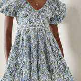 Woman wearing blue floral cotton mini dress with puff sleeves and cream tote bag — Agua by Agua Bendita | Endless UAE