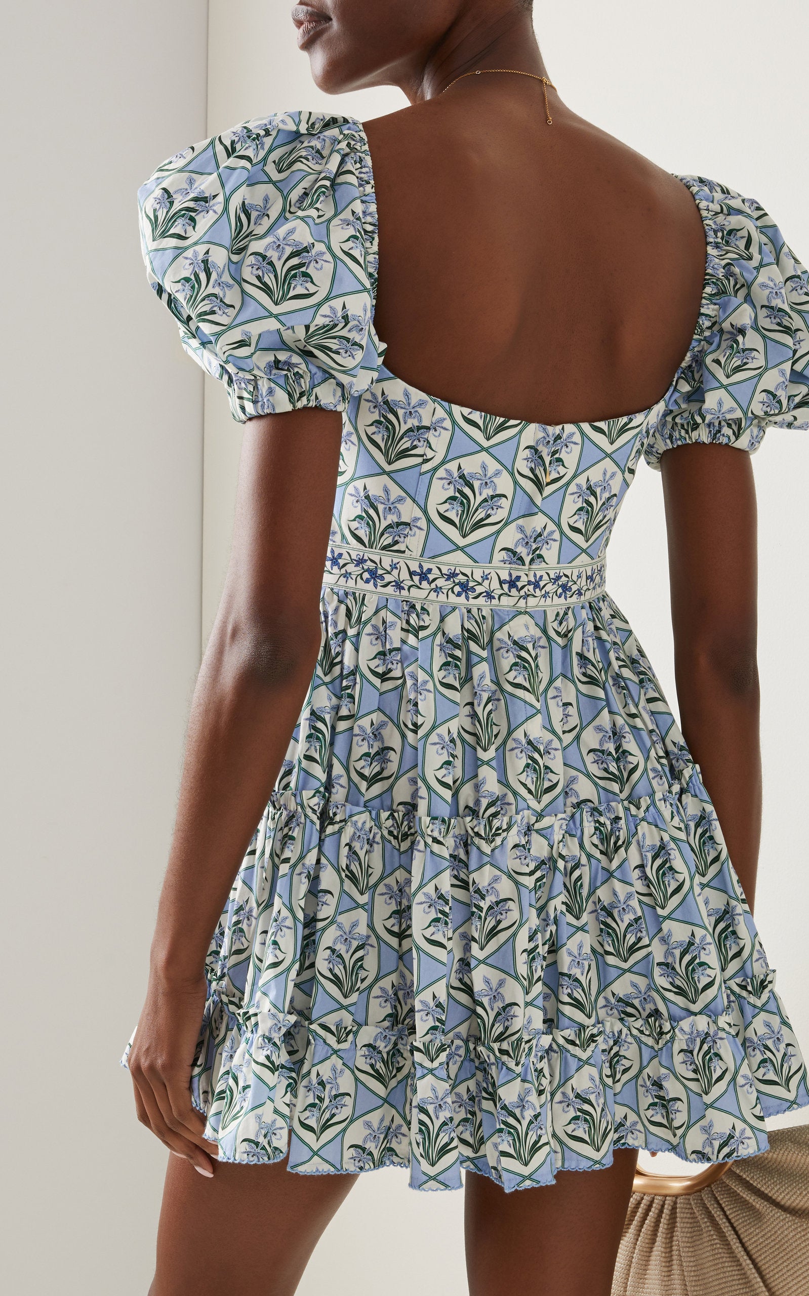 Woman wearing blue floral cotton mini dress with puff sleeves and cream tote bag — Agua by Agua Bendita | Endless UAE