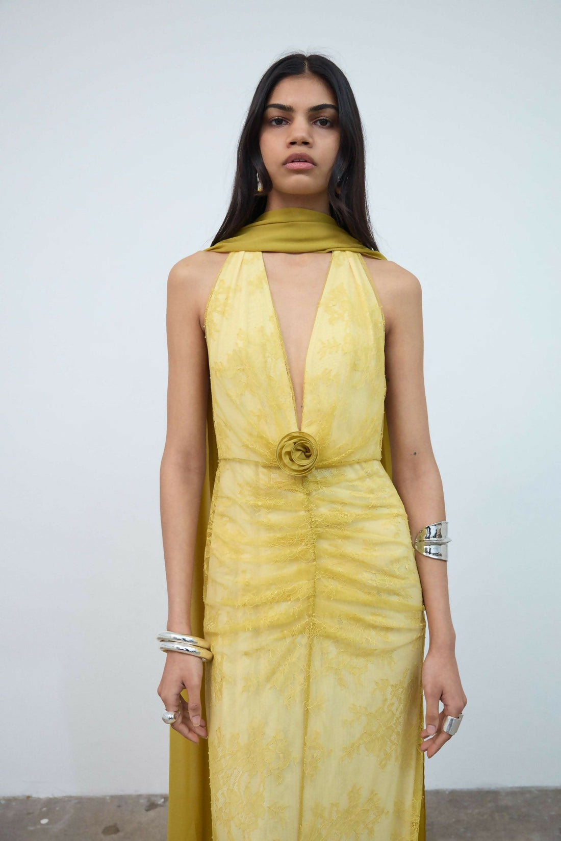 Woman wearing yellow halter maxi dress with deep V-neckline and circular buckle detail — Endless | Endless UAE