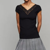Black ribbed knit top with delicate lace V-neck trim and short sleeves, paired with plaid skirt — Maje | Endless UAE