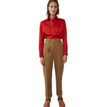 Woman wearing tan Madya Co chinos with cuffed hems and red polo shirt, styled with leather sandals — Acne Studios | Endless UAE
