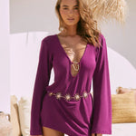 Purple mini dress with plunging neckline, long sleeves, and gold sun chain belt detail — Beach City | Endless UAE