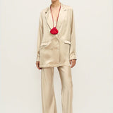 Woman wearing a relaxed hazelnut blazer and matching trousers with a red pendant necklace — Silk Laundry | Endless UAE