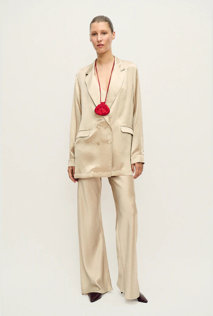 Woman wearing a relaxed hazelnut blazer and matching trousers with a red pendant necklace — Silk Laundry | Endless UAE