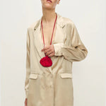 Woman wearing a relaxed hazelnut blazer and matching trousers with a red pendant necklace — Silk Laundry | Endless UAE
