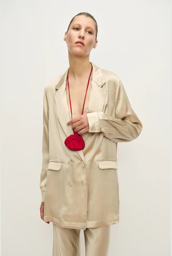 Woman wearing a relaxed hazelnut blazer and matching trousers with a red pendant necklace — Silk Laundry | Endless UAE