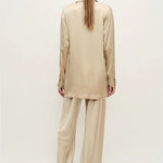 Woman wearing a relaxed hazelnut blazer and matching trousers with a red pendant necklace — Silk Laundry | Endless UAE
