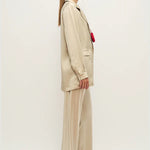 Woman wearing a relaxed hazelnut blazer and matching trousers with a red pendant necklace — Silk Laundry | Endless UAE