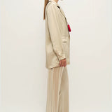Woman wearing a relaxed hazelnut blazer and matching trousers with a red pendant necklace — Silk Laundry | Endless UAE