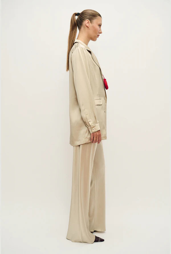 Woman wearing a relaxed hazelnut blazer and matching trousers with a red pendant necklace — Silk Laundry | Endless UAE