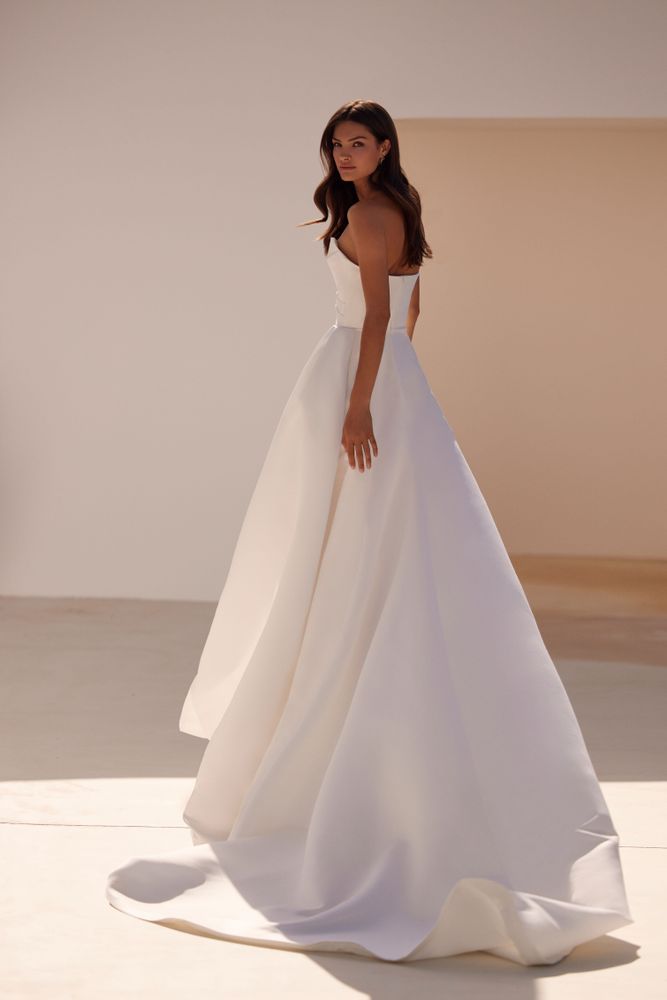 Elegant strapless white A-line wedding gown with structured bodice and flowing skirt with train — Milla Nova | Endless UAE