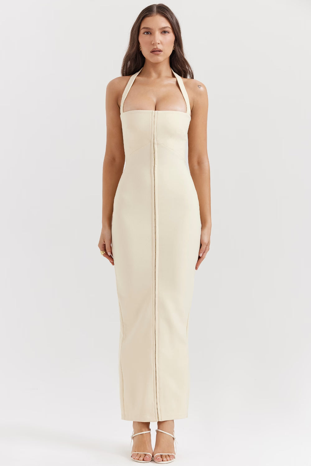 Woman wearing cream halter maxi dress with front zip detail and strappy white sandals — House of CB | Endless UAE