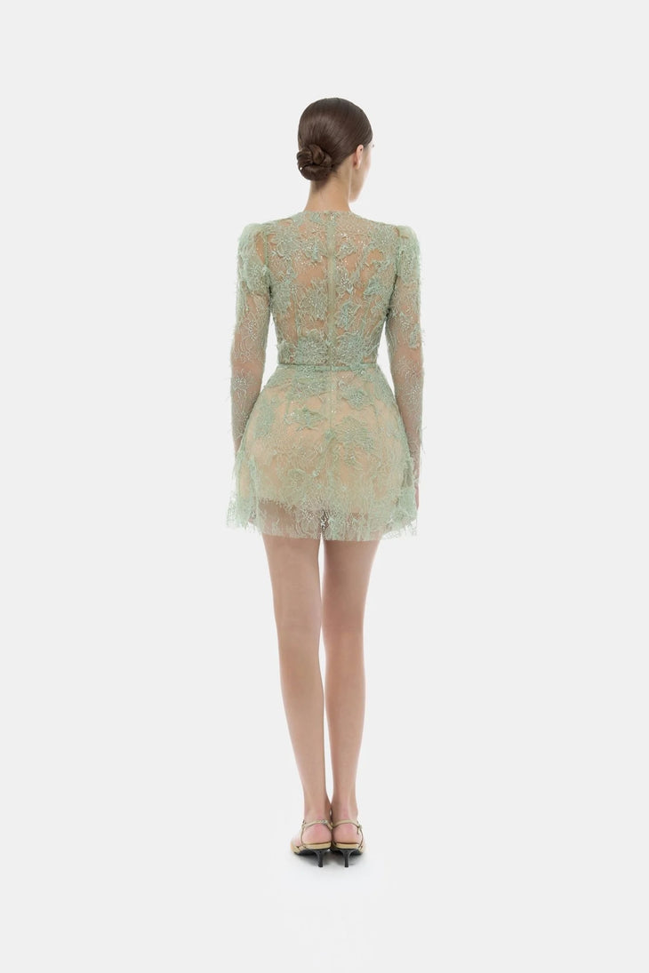 Rear view of model wearing mint green beaded lace mini dress with long sleeves and sheer detailing — Montsand | Endless UAE