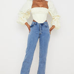 Elegant cream corset top with dramatic balloon sleeves paired with blue jeans on model — House of CB | Endless UAE
