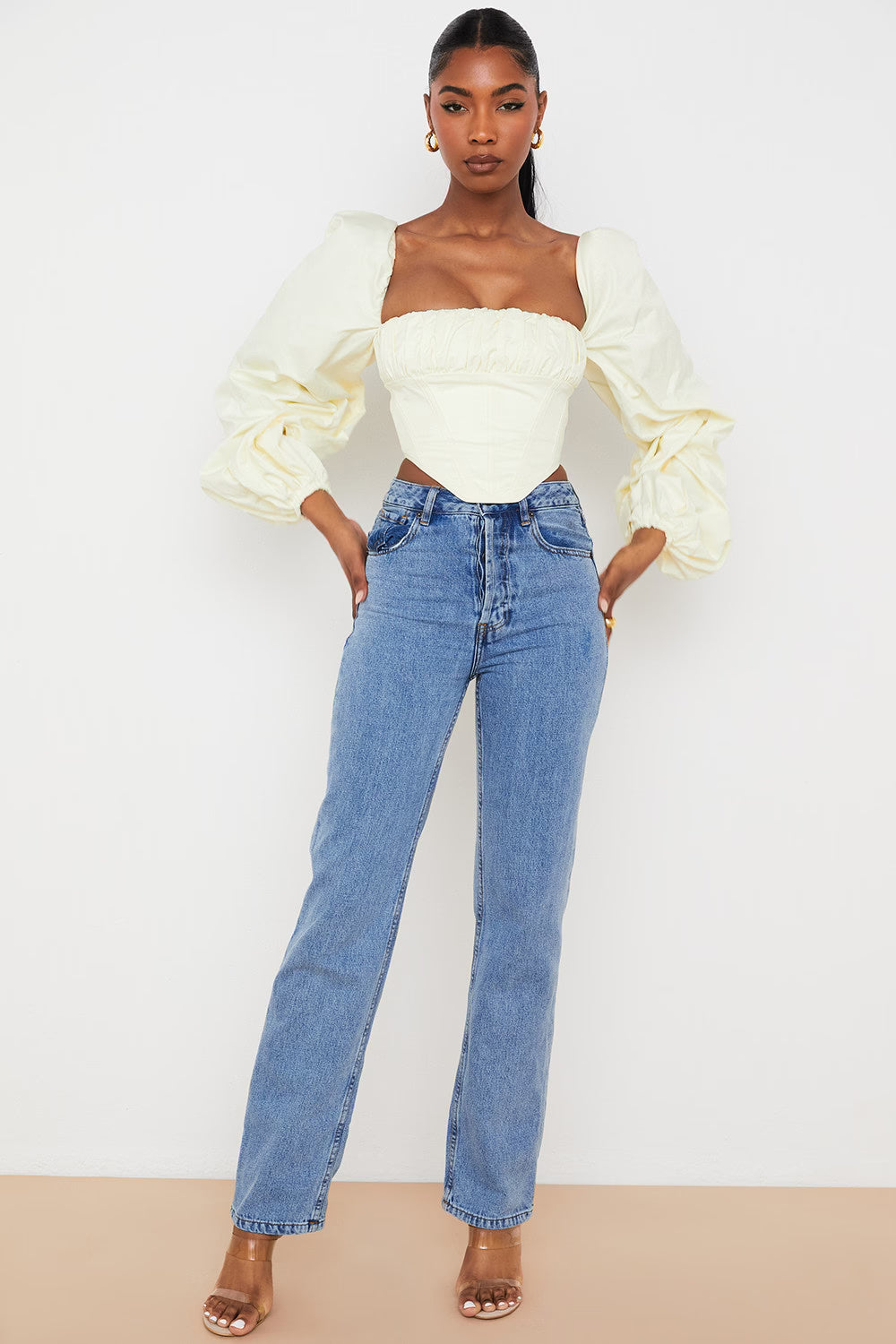 Elegant cream corset top with dramatic balloon sleeves paired with blue jeans on model — House of CB | Endless UAE