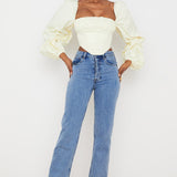 Elegant cream corset top with dramatic balloon sleeves paired with blue jeans on model — House of CB | Endless UAE