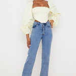 Elegant cream corset top with dramatic balloon sleeves paired with light blue straight-leg jeans — House of CB | Endless UAE