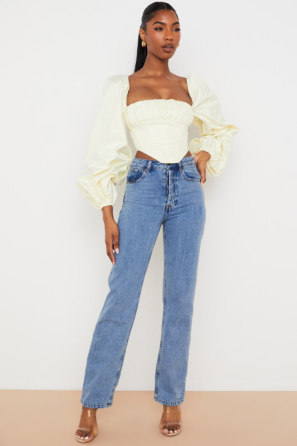 Elegant cream corset top with dramatic balloon sleeves paired with light blue straight-leg jeans — House of CB | Endless UAE