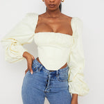 Cream off-shoulder corset top with dramatic balloon sleeves paired with blue jeans — House of CB | Endless UAE