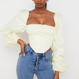 Cream off-shoulder corset top with dramatic balloon sleeves paired with blue jeans — House of CB | Endless UAE