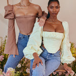 Miriam Balloon Sleeve Corset in taupe and yellow worn with jeans by two models in floral setting — House of CB | Endless UAE