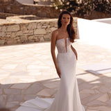 Strapless fitted wedding gown with sheer lace bodice and flowing train in Mediterranean setting — You&I Bridal | Endless UAE