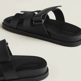 Black leather slide sandals with adjustable buckle straps and textured rubber sole — Hermes | Endless UAE