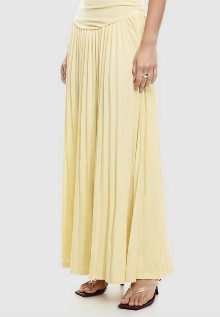 Woman wearing pale yellow off-shoulder maxi dress with ruched bodice and pleated skirt — Lioness | Endless UAE