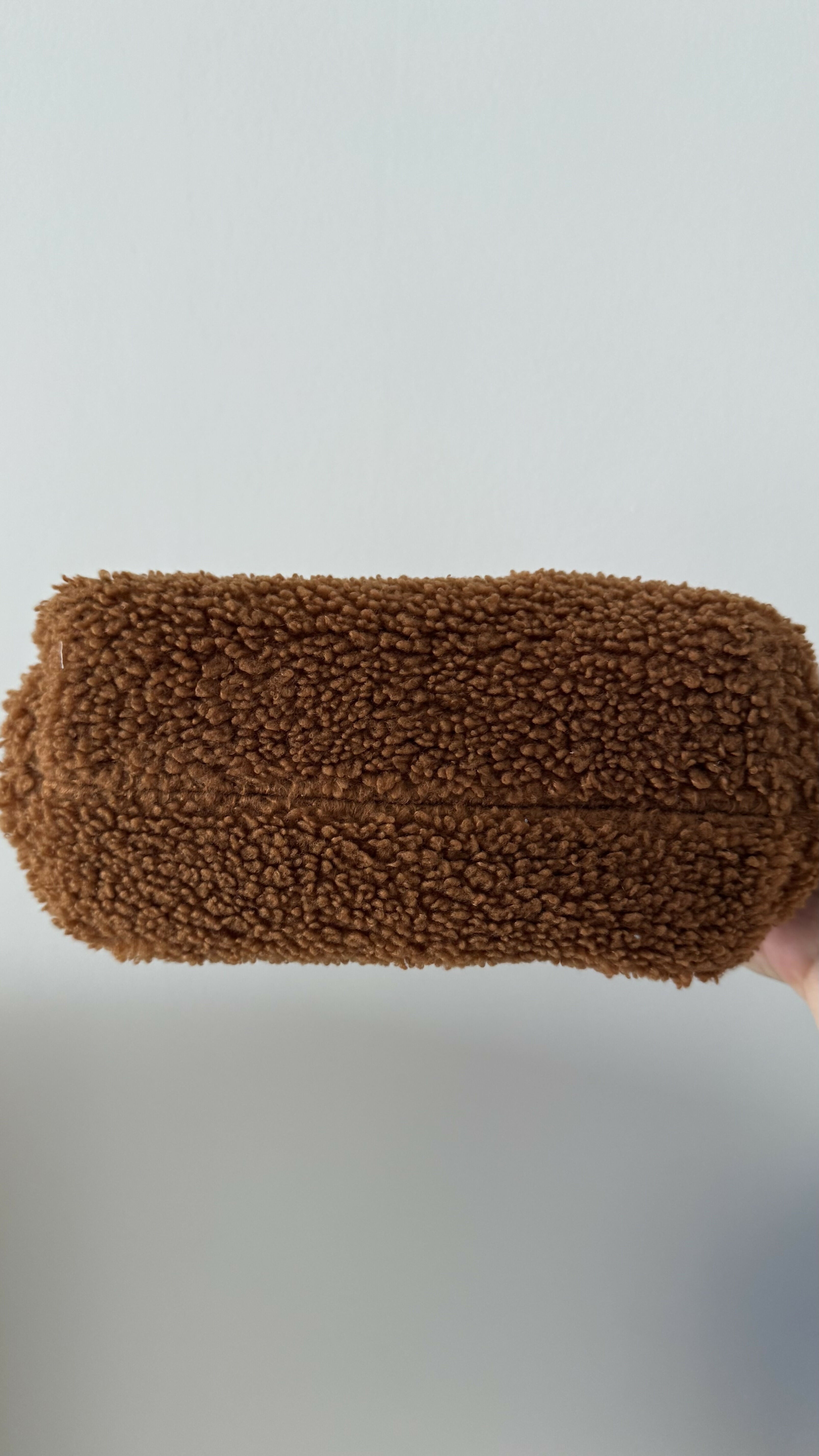 Gea Clutch in caramel brown textured fabric held in hand — TheMoire | Endless UAE