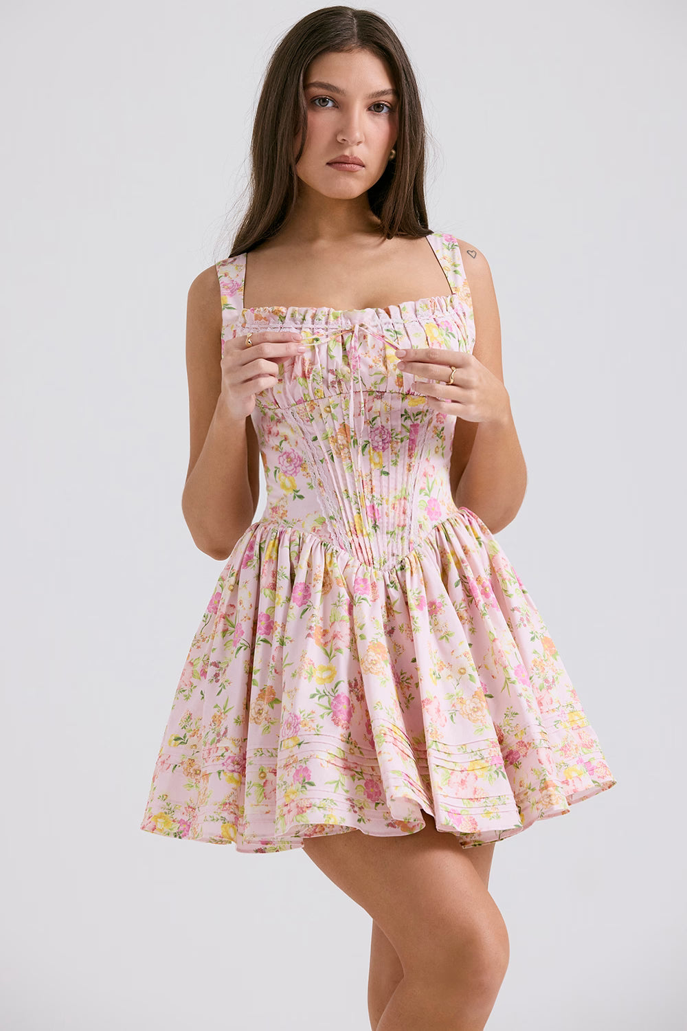 Pink floral print mini dress with gathered bodice, adjustable straps and full skirt modeled on brunette woman — House of CB | Endless UAE