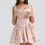 Pink floral print mini dress with gathered bodice, adjustable straps and full skirt modeled on brunette woman — House of CB | Endless UAE