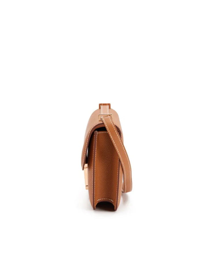 Cognac brown leather Constance Elan crossbody bag with contrast stitching and rose gold hardware side view — Hermes | Endless UAE