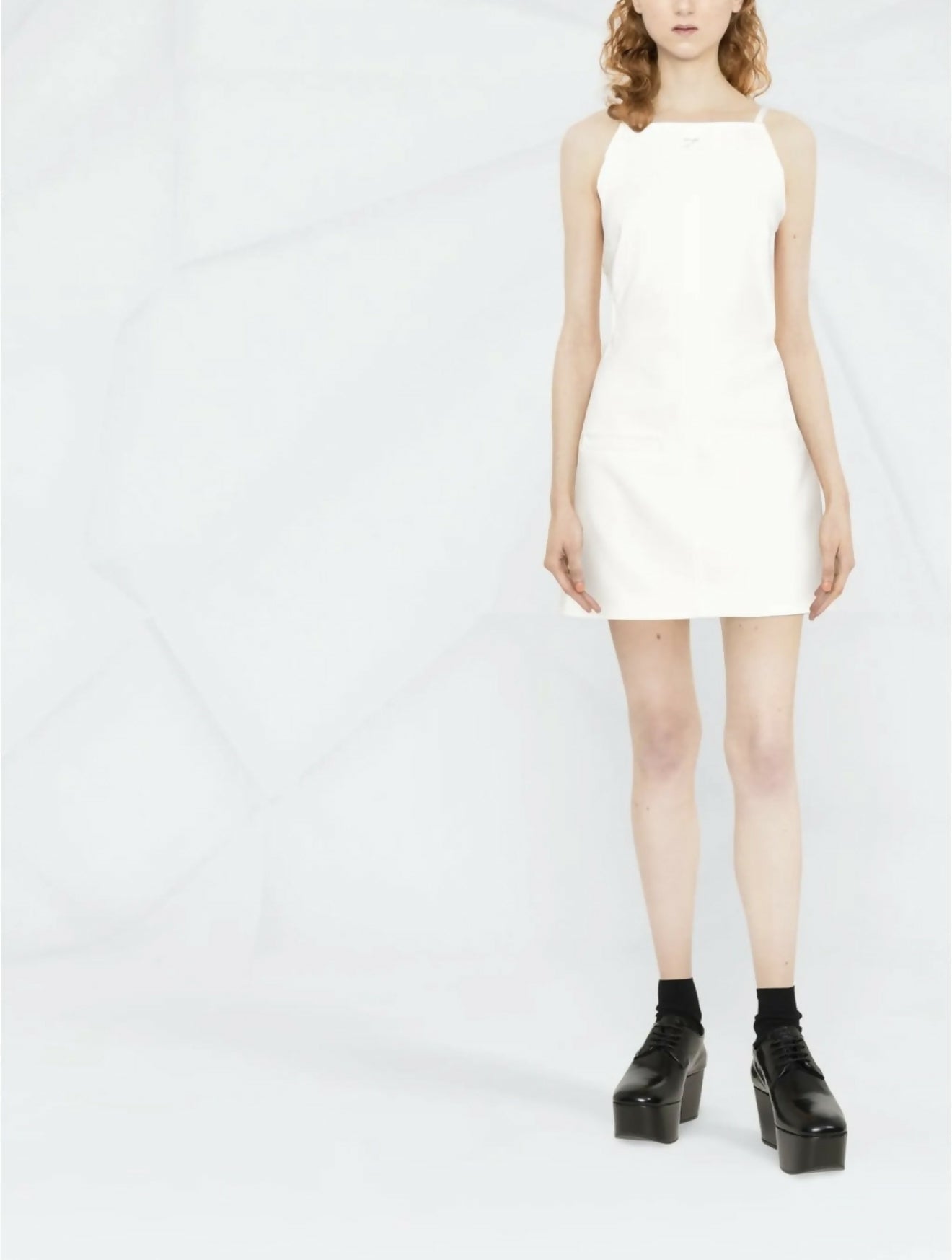 White sleeveless mini dress with square neckline and cut-out back detail, styled with platform boots — Courrèges | Endless UAE