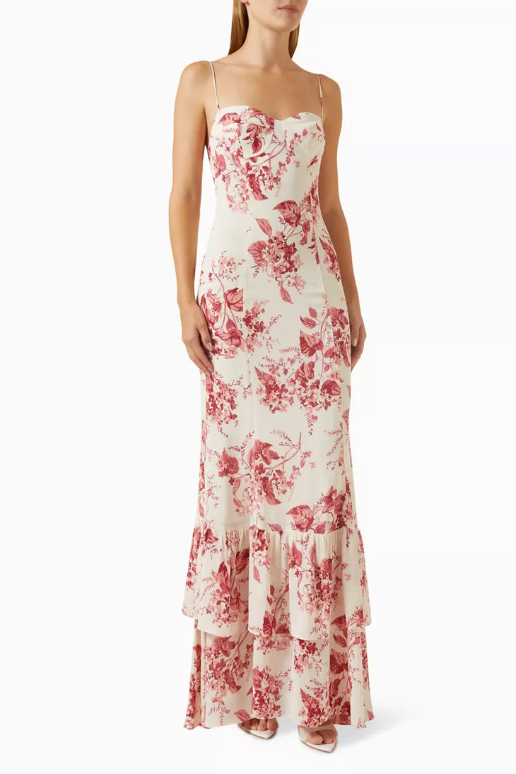 Woman wearing a cream and pink floral maxi dress with spaghetti straps and tiered ruffled hem — Reformation | Endless UAE