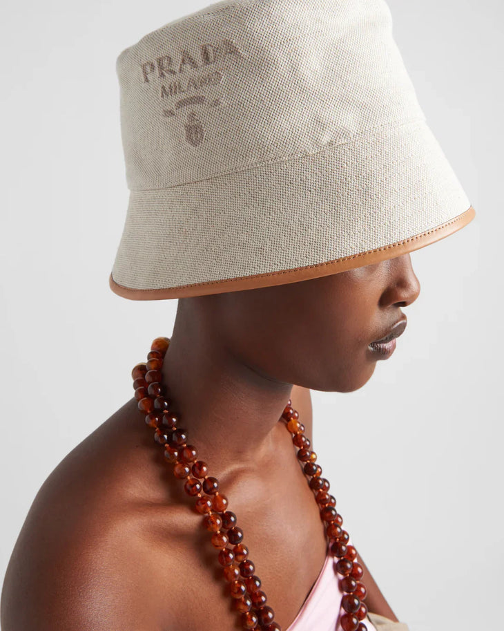 Cream linen blend bucket hat with tan leather trim and Prada logo — Prada | Endless UAE