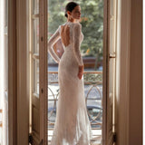 Elegant white lace wedding dress with long sleeves and flowing tulle train — Tatiana Kaplun | Endless UAE