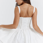 White corset mini dress with lace-up back detail and flared skirt, shown from behind — House of CB | Endless UAE