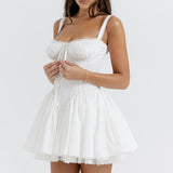 White corset mini dress with lace trim, smocked bodice, and flared skirt modeled on woman — House of CB | Endless UAE