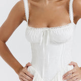 White corset mini dress with lace trim, ribbon detail, and gathered bust worn by brunette model — House of CB | Endless UAE