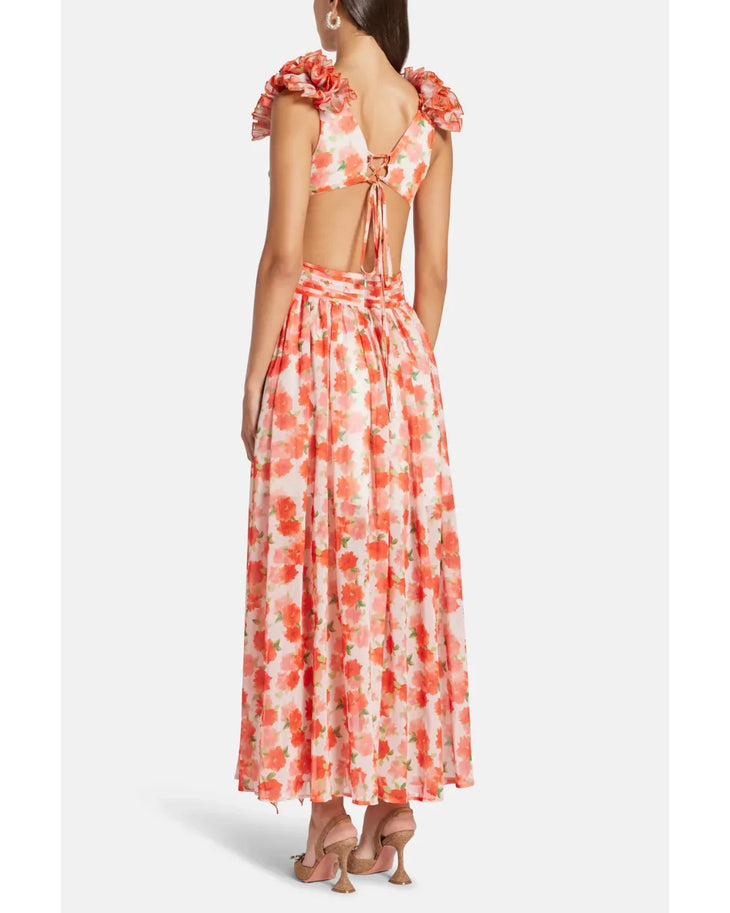 Woman wearing a coral floral maxi dress with flutter sleeves and cutout waist detail — Anne Louise Boutique | Endless UAE