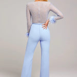 Woman wearing lavender beaded crop top with feathered cuffs and light blue wide-leg trousers — Nadine Merabi | Endless UAE