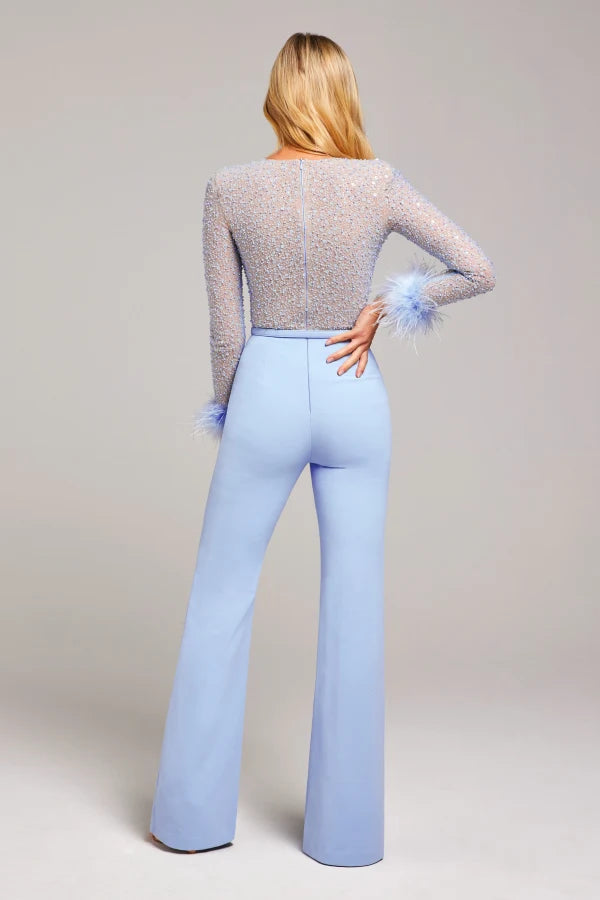 Woman wearing lavender beaded crop top with feathered cuffs and light blue wide-leg trousers — Nadine Merabi | Endless UAE