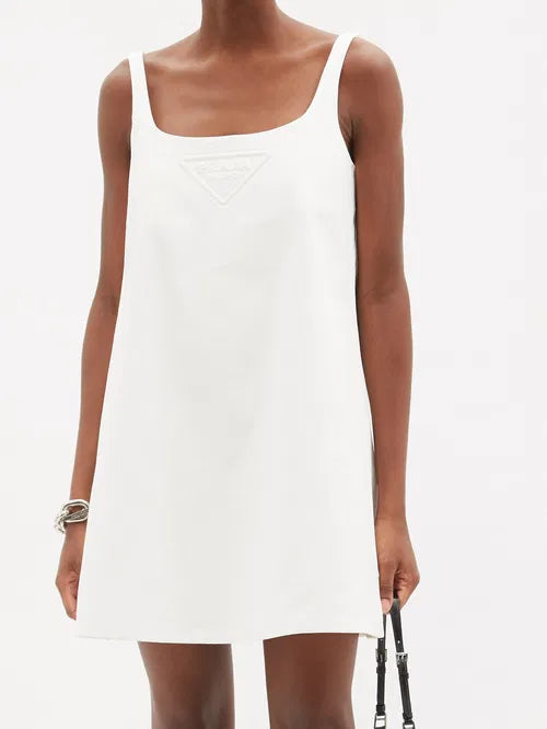 White cotton-drill mini dress with embossed triangle logo and square neckline on model — Prada | Endless UAE