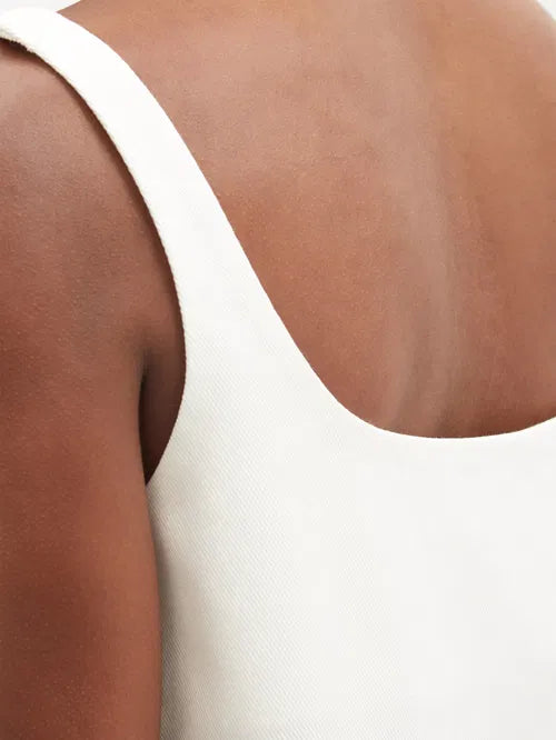 White cotton-drill mini dress with triangle embossed detail and sleeveless design — Prada | Endless UAE