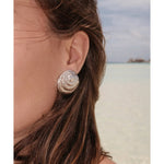 Textured gold seashell dome stud earrings worn on model at beach — Monday Swimwear | Endless UAE