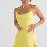 Woman wearing yellow satin mini dress with cowl neckline, thin straps, and ruffled hem detail — House of CB | Endless UAE