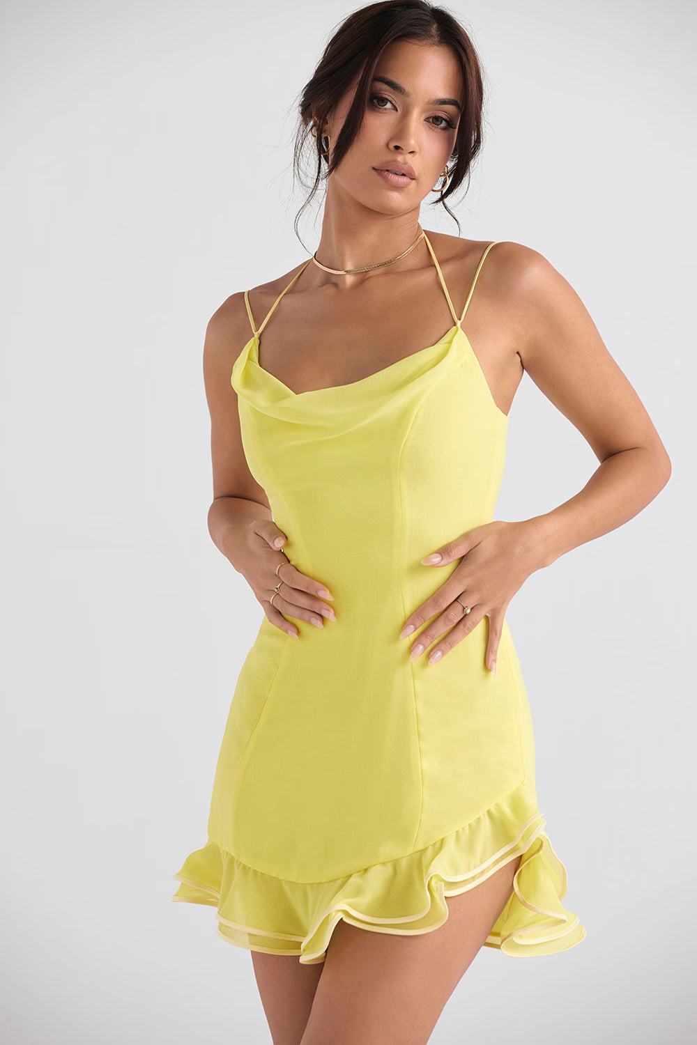 Woman wearing yellow satin mini dress with cowl neckline, thin straps, and ruffled hem detail — House of CB | Endless UAE