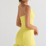 Bright yellow mini dress with spaghetti straps, halter neck tie, and ruffled hem modeled from back — House of CB | Endless UAE